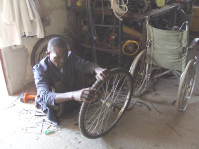 Paraplegic Daniel Kangogo working on one of the puncture-proof tyres for a new 6-wheeler model.